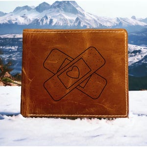 Cartera de cuero con forma de corazón con diseño de vendaje, plegable, de primera calidad, Buffalo Hurt Pain, NUEVA