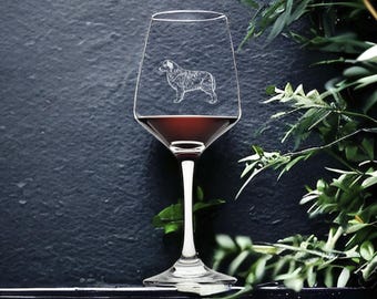 Könnte beinhalten: Ein klares Weinglas mit Rotwein. Das Glas hat ein geätztes Design eines schwarz-weißen Hundes an der Seite.