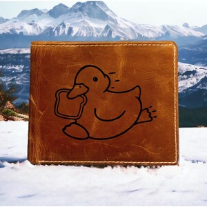 May include: A brown leather wallet with a black outline of a duck holding a piece of bread.
