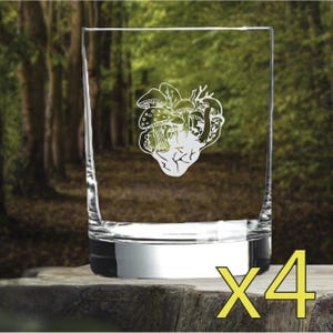 Pode incluir: Conjunto de quatro copos transparentes de vidro com um desenho gravado em branco de um coração feito de cogumelos. Os copos têm uma base prateada.