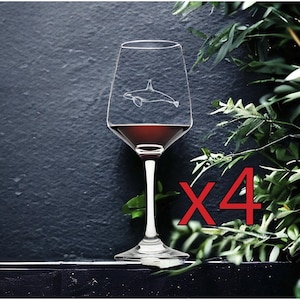 May include: A wine glass with a detailed etched orca design, filled with red liquid. The glass is set against a dark background with foliage. The number "X4" is written in red.