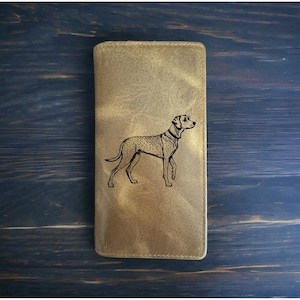 May include: A brown leather wallet with a black and white illustration of a dog on the front.