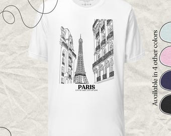 May include: White t-shirt featuring a black and white illustration of the Eiffel Tower in Paris, France, with surrounding buildings. The word "PARIS" and the phrase "CITY OF LIGHT, CITY OF LOVE" are printed below the image. Available in 4 other colors.