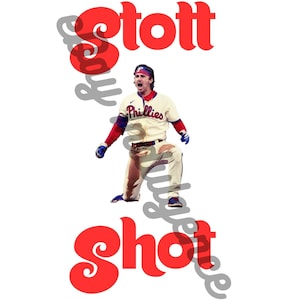 Puede incluir: Un jugador de béisbol con un jersey blanco con ribetes rojos y azules, con la palabra "Phillies" en el frente, está en posición de bateo. El jugador lleva una gorra de béisbol roja con un logotipo blanco. Las palabras "Stott" y "Shot" están en letras rojas grandes arriba y abajo del jugador.