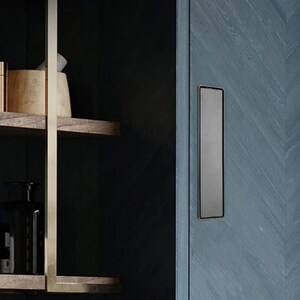 May include: A dark blue cabinet door with a herringbone pattern and a long, narrow, black metal handle.