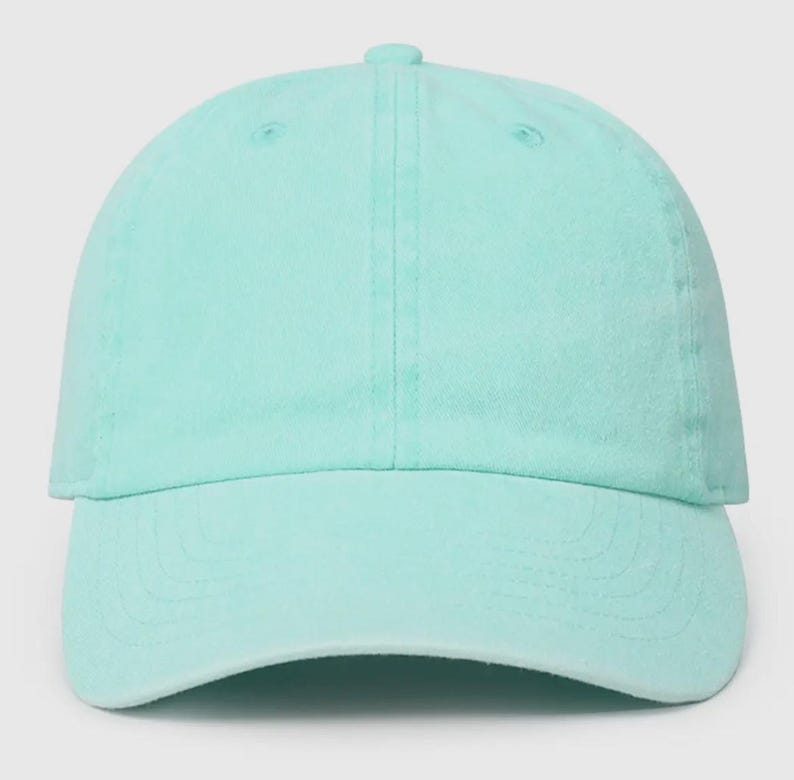 May include: A plain, light blue baseball cap. The cap has a curved brim and a structured crown.