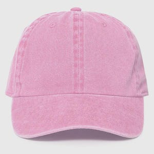 May include: A pink, cotton baseball cap with a slightly distressed look.