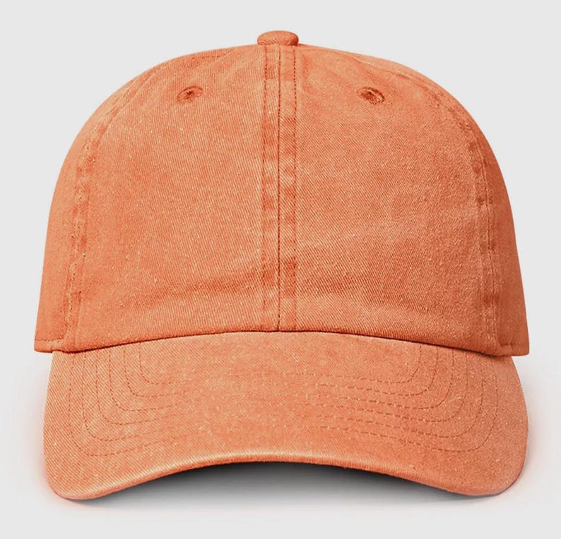 May include: A solid orange baseball cap with a slightly distressed look. The cap has a curved brim and a traditional six-panel design.
