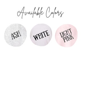 Puede incluir: Tres muestras de tela que muestran los colores disponibles para una camiseta: ceniza, blanco y rosa claro.