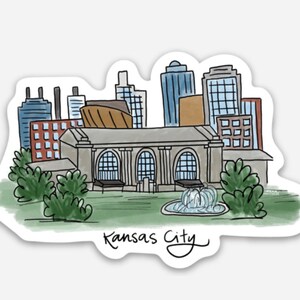 Puede incluir: Una ilustraci&oacute;n de acuarela del horizonte de Kansas City, con un gran edificio con ventanas arqueadas, rodeado de edificios m&aacute;s peque&ntilde;os y &aacute;rboles. El texto "Kansas City" est&aacute; escrito en cursiva en la parte inferior de la imagen.