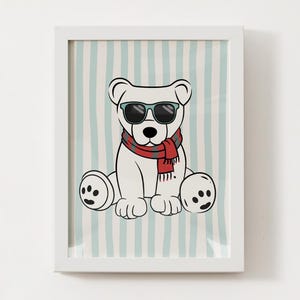 May include: A framed print featuring a cartoon polar bear wearing sunglasses and a red scarf. The bear is sitting against a light blue and white striped background. The print is in a white frame.