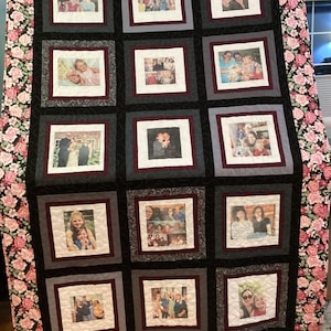Può includere: Un quilt bianco e nero con un bordo floreale. Il quilt è composto da quadrati, ognuno dei quali contiene una fotografia diversa di persone. Le foto sono in bianco e nero e sono incorniciate da un bordo bianco.