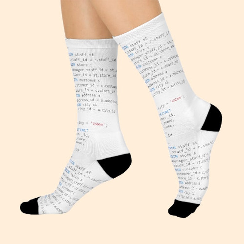 May include: White socks with a black toe and heel, featuring a code snippet printed on the fabric. The code snippet includes SQL commands for joining tables, such as 'staff', 'store', 'customer', 'address', and 'city'. The code snippet also includes the word 'Lisbon'.