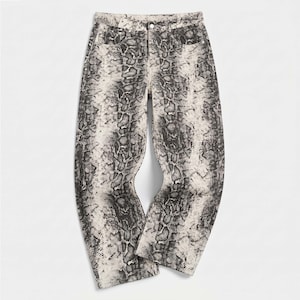 May include: Full-length denim jeans featuring a high-contrast black and off-white snakeskin print pattern. The trousers include a standard waistband with a single button closure, belt loops, two front pockets, and a straight-leg cut design.
