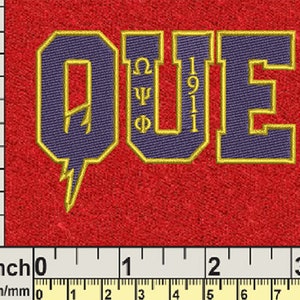 May include: A purple and gold embroidered patch with the letters "QUE" and the numbers "1911" inside. The letters are outlined in gold and the numbers are in a smaller font.