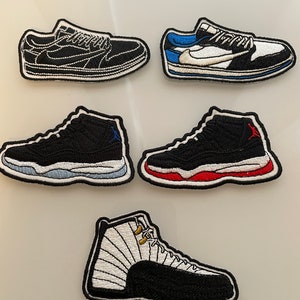 May include: Five embroidered iron-on patches of different basketball shoe designs. The patches are black, white, red, and blue.