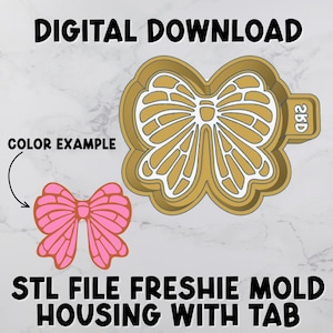 May include: A bow-shaped STL file freshie mold with a tab, shown in gold with white detailing. A pink bow color example is shown next to the mold. The text "DIGITAL DOWNLOAD" and "STL FILE FRESHIE MOLD HOUSING WITH TAB" are displayed.