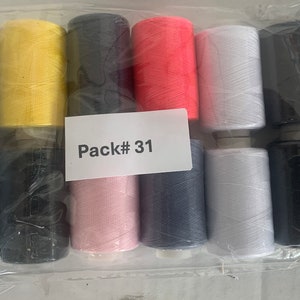 Op de afbeelding: Een verpakking met 10 spoelen garen in verschillende kleuren, waaronder zwart, wit, roze, blauw, geel en rood. De verpakking is gelabeld "Pack # 31".