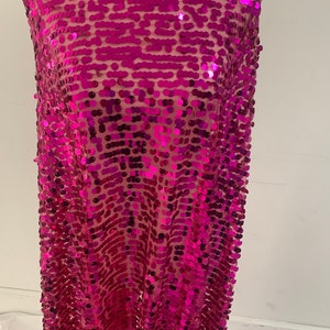 May include: Pink sequin fabric with a mesh backing. The sequins are round and have a slight iridescent sheen.