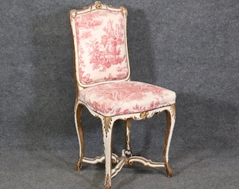 May include: A white and gold painted wooden chair with a pink and white floral patterned fabric seat.