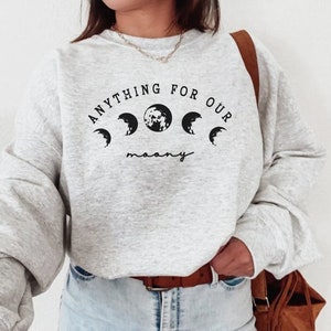 Könnte beinhalten: Grauer Pullover mit dem Text "Anything for our moon" und einer Grafik mit fünf Mondphasen.