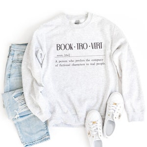 May include: A gray sweatshirt with the text "BOOK-TRO-VERT" and a definition: "A person who prefers the company of fictional characters to real people."