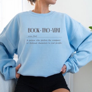 May include: Light blue sweatshirt with the text "BOOK-TRO-VERT" and the definition: "A person who prefers the company of fictional characters to real people."