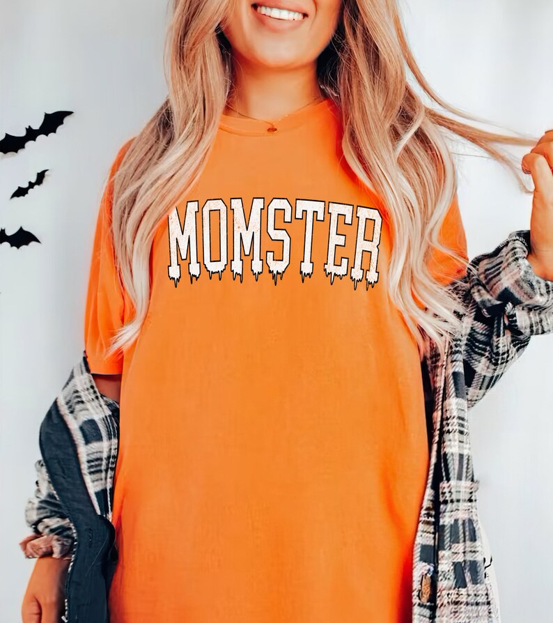 May include: Orange t-shirt with the text "MOMSTER" in white dripping letters.