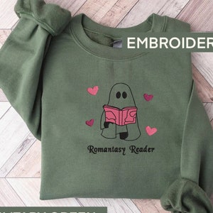 May include: Green sweatshirt with an embroidered design of a ghost reading a book with the text "Romantasy Reader" and pink hearts.