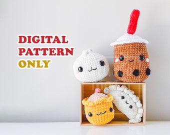 May include: Four crocheted amigurumi plushies in a wooden box. The plushies are shaped like a boba tea, a dumpling, a steamed bun, and a bao. The boba tea is brown with a red straw, the dumpling is white, the steamed bun is yellow, and the bao is white. All of the plushies have cute faces.