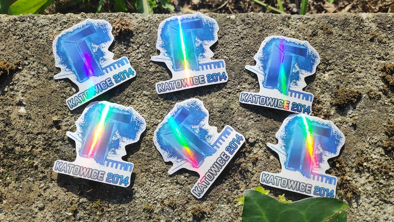 May include: Six iridescent holographic stickers with the text "KATOWICE 2014" and a stylized letter "T" design.