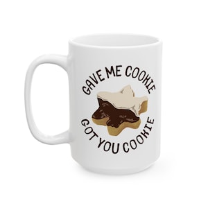 May include: White ceramic mug with a brown and white cookie design and the text "Gave me cookie got you cookie".