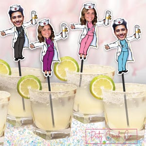 May include: Four personalized cake toppers featuring cartoon nurses with graduation caps and diplomas. The toppers are on sticks and are placed in front of four margarita glasses with lime wedges.