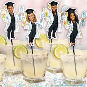 May include: A festive image featuring margarita cocktails garnished with lime slices and salt-rimmed glasses. The drinks are decorated with graduation-themed toppers of cartoon dentists holding toothbrushes and diplomas. The background is a soft pink with confetti.
