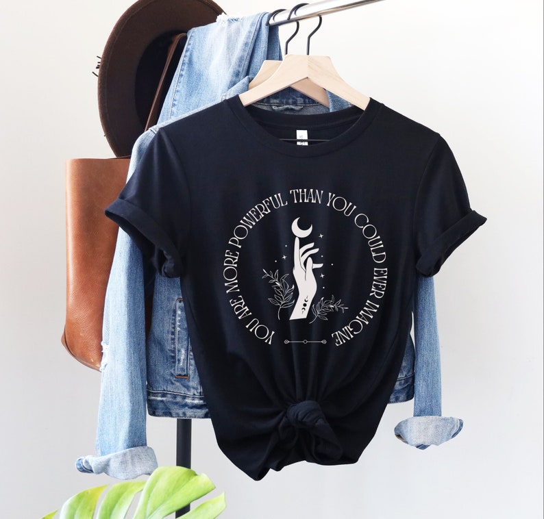 May include: Black t-shirt with a white graphic design of a hand holding a crescent moon. The text around the graphic reads "You are more powerful than you could ever imagine."