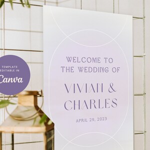 May include: A wedding welcome sign with a purple and white gradient background. The sign features a white circle with the text "Welcome to the Wedding of Vivian & Charles" and the date "April 29, 2023".