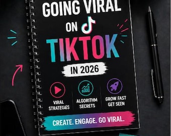 Op de afbeelding: Een zwart spiraalgebonden boek getiteld "The Ultimate Guide to Going Viral on TikTok in 2026" met het TikTok-logo. De omslag heeft roze, blauwe en witte tekst. Een koffiekopje, pen en plaknotities liggen ook op het zwarte oppervlak.