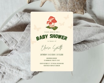 Op de afbeelding: Een baby shower uitnodiging met een paddenstoel en vlinder thema. De uitnodiging is crèmekleurig met groene tekst en bevat een groep rode paddenstoelen met witte stippen. De tekst luidt "Kom gezellig met ons mee naar een baby shower ter ere van Eloise Smith. Zaterdag 9/2/20XX 13:30 uur. Mushroom Clubhouse 123 Shroom Ave, Your City, State. RSVP vóór 1 oktober - Stuur een sms of bel 000-000-0000. Geregistreerd bij Babylist & Amazon."