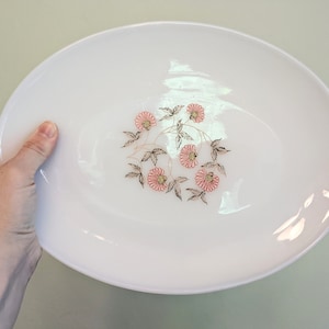 May include: White oval serving platter with a floral design featuring pink flowers and gold-colored leaves.