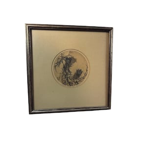 Puede incluir: Una obra de arte cuadrada enmarcada que presenta un grabado circular en blanco y negro de plantas similares a cardos. La impresión está centrada sobre un paspartú beige claro dentro de un marco metálico oscuro con acabado texturizado.