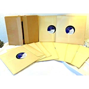 May include: A set of 10 brown paper record sleeves with blue and white labels. The sleeves are for 12-inch vinyl records. The sleeves are in a cardboard box.