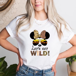 May include: White t-shirt with a cartoon image of a mouse wearing sunglasses and a bow. The mouse is surrounded by a jungle scene. The text "Let's Get Wild!" is printed below the image.