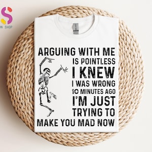 May include: White t-shirt with a humorous graphic. The design features a skeleton illustration and the text: "ARGUING WITH ME IS POINTLESS I KNEW I WAS WRONG 10 MINUTES AGO I'M JUST TRYING TO MAKE YOU MAD NOW."