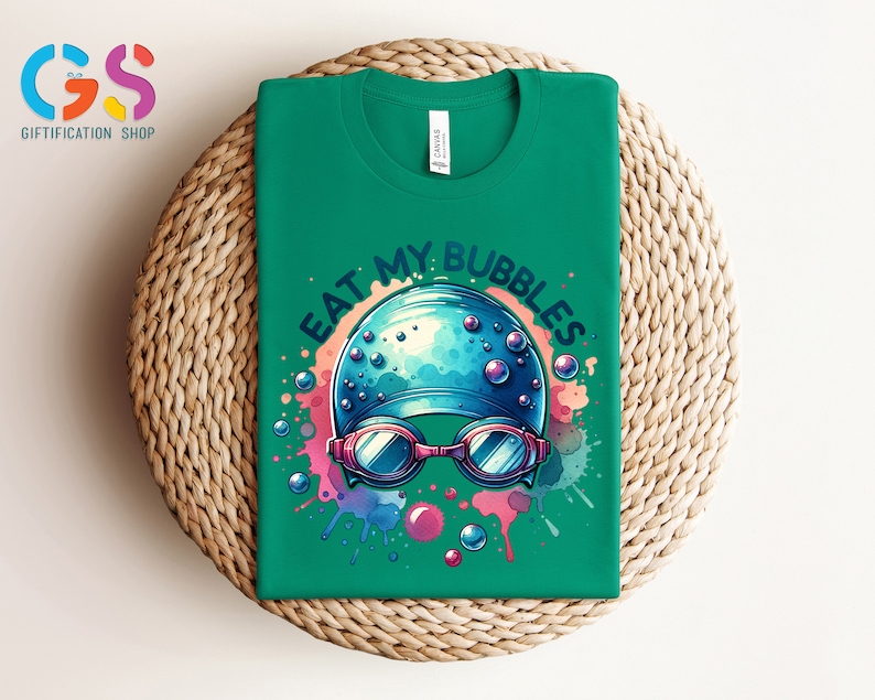 May include: Green t-shirt with a colorful graphic of a swimmer's cap with goggles and the text "Eat My Bubbles".