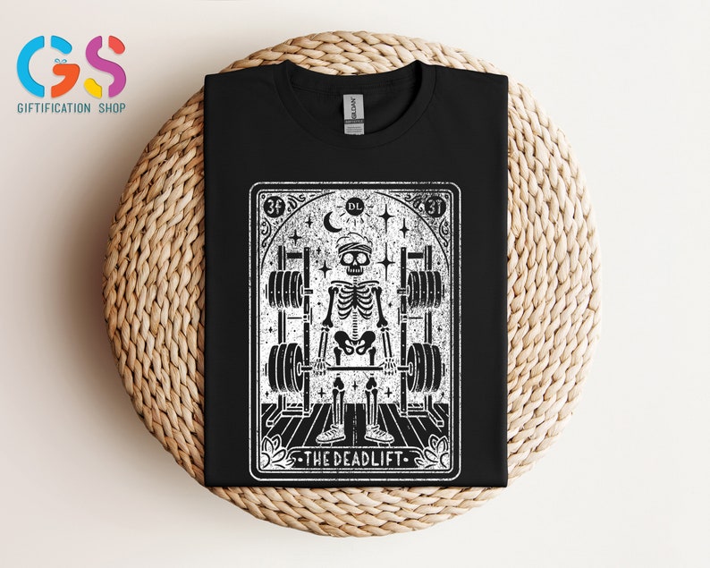 May include: Black and white illustration of a skeleton lifting weights. The illustration is in the style of a tarot card with the text "The Deadlift" at the bottom.