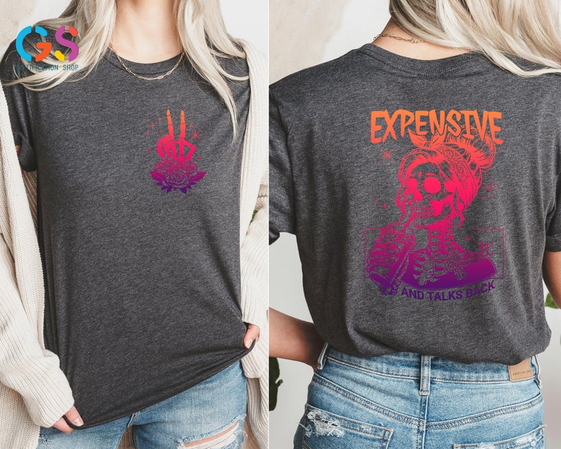 May include: A gray t-shirt with a pink and orange gradient design. The front of the shirt features a skeleton hand with roses. The back of the shirt features a skeleton with a bun and the text "EXPENSIVE AND TALKS BACK".