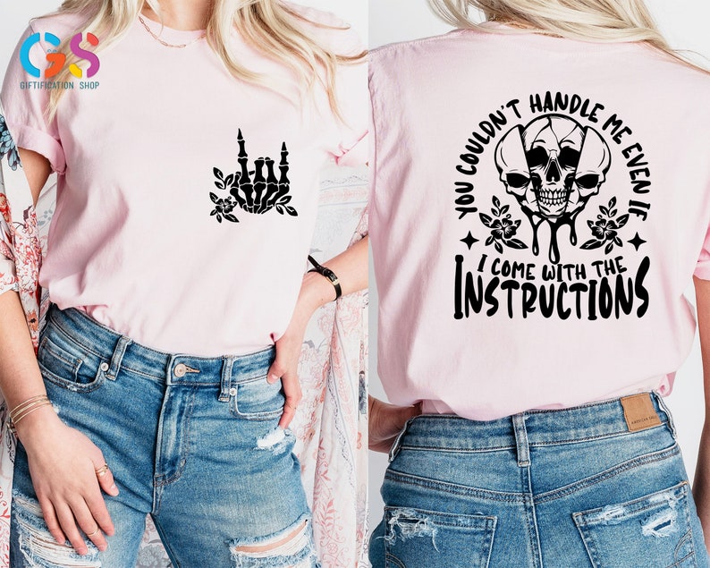 Op de afbeelding: Roze T-shirt met een zwarte schedelprint en de tekst "You couldn't handle me even if I come with the instructions".