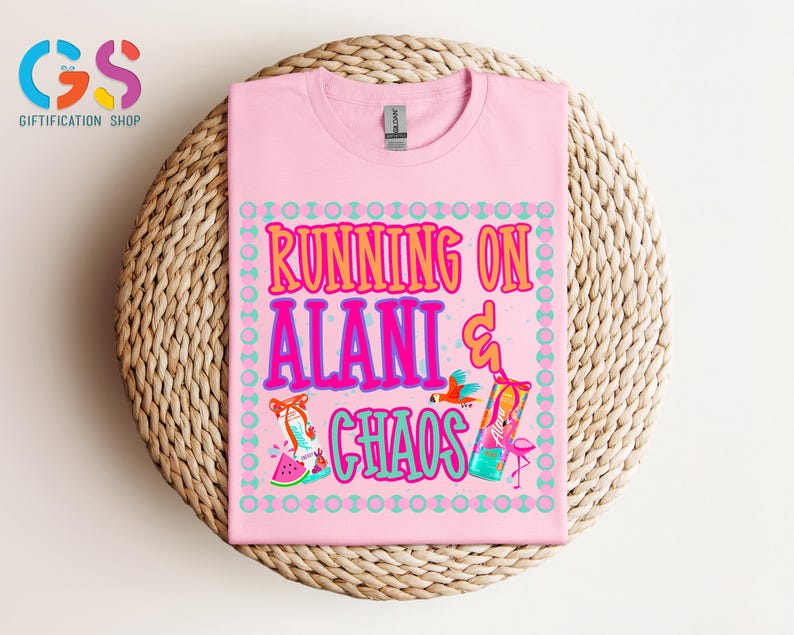 Puede incluir: Camiseta rosa claro con la frase "RUNNING ON ALANI & CHAOS" en un dise&ntilde;o colorido. El dise&ntilde;o incluye ilustraciones de un loro, un c&oacute;ctel, un flamenco y una rodaja de sand&iacute;a. La camiseta est&aacute; doblada sobre una superficie tejida.