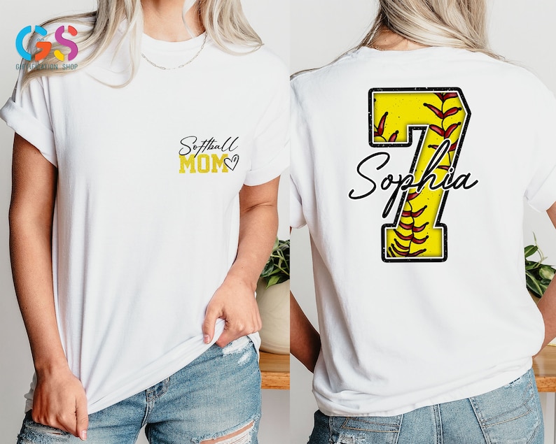 May include: White t-shirt with the text "Softball Mom" and a heart on the front. The back of the shirt has a yellow softball with red stitching and the number 7 with the name "Sophia" underneath.