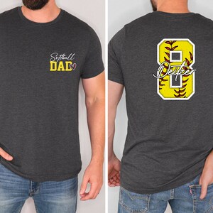 May include: A dark grey t-shirt with the text "Softball Dad" and a heart on the front. The back of the shirt has a white number 8 with a yellow softball inside and the text "Dexter" underneath.